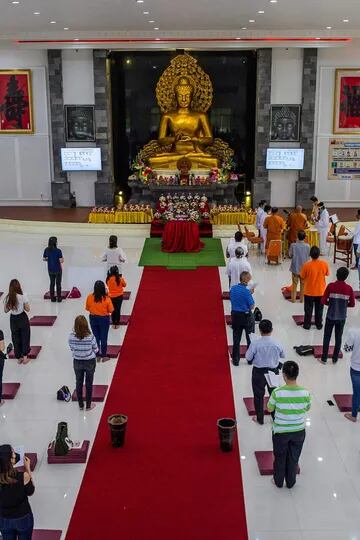 Devotos rezan junto a una estatua de Buda para conmemorar el Día de Vesak, en la ciudad de Surabaya, Java