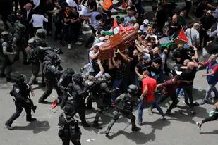 Policías israelíes confrontan a dolientes que llevan el féretro de la veterana periodista de Al Jazeera Shireen Abu Akleh en Jerusalén oriental el 13 de mayo del 2022.  (AP Foto/Maya Levin)