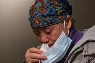 Esta foto tomada el 25 de noviembre de 2020 muestra a Zhong Hanneng secándose las lágrimas mientras habla de su hijo que murió de Covid-19 en Wuhan, provincia central de Hubei en China